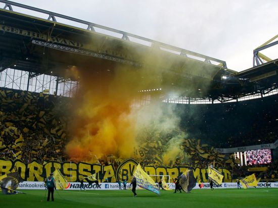 Fans von Dortmund brennen vor einem Spiel Rauch-Pyrotechnik ab.