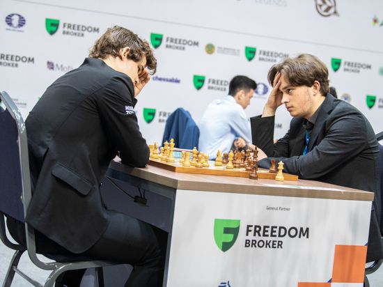 Vincent Keymer (rechts) spielt eine Schachpartie gegen den Norweger Magnus Carlsen.