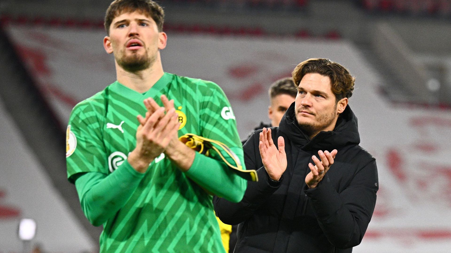 Dortmunds Torwart Gregor Kobel (l) und Trainer Edin Terzic verabscheden sich nach dem Pokal-Aus von den Fans.