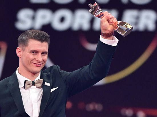 Der Barren-Weltmeister Lukas Dauser reckt auf der Bühne des Bénazet-Saals die Goldene Statue als Sportler des Jahres in die Höhe. 
